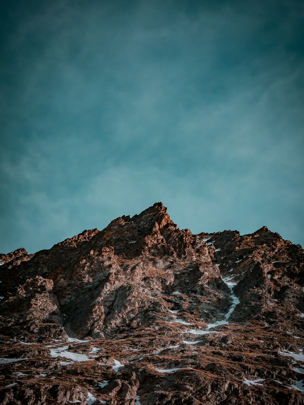 the top of a mountain with a blue sky in the background