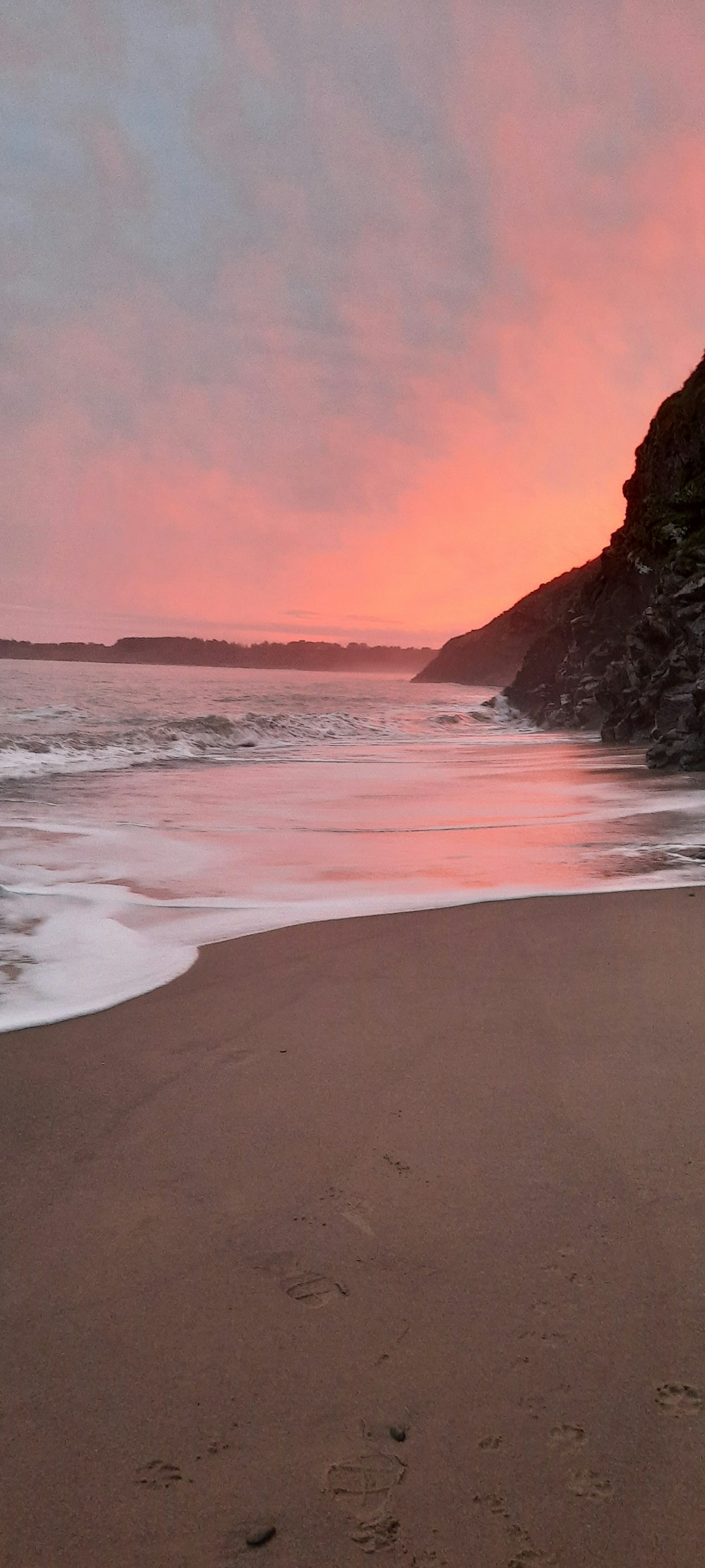 a person walking on a beach with a surfboard