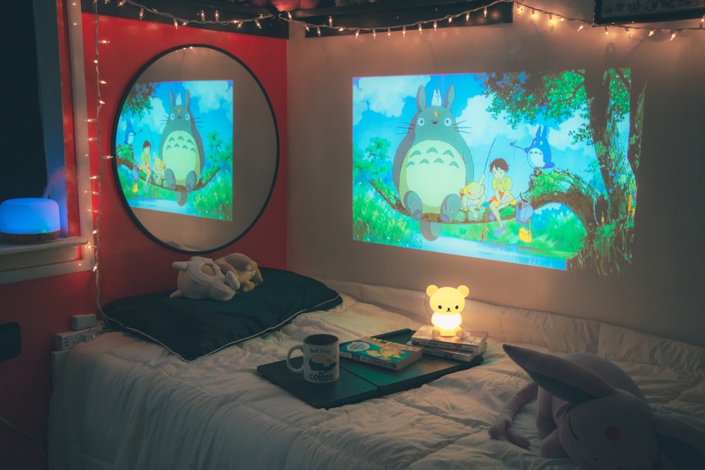 a bedroom with a bed and two large screens on the wall