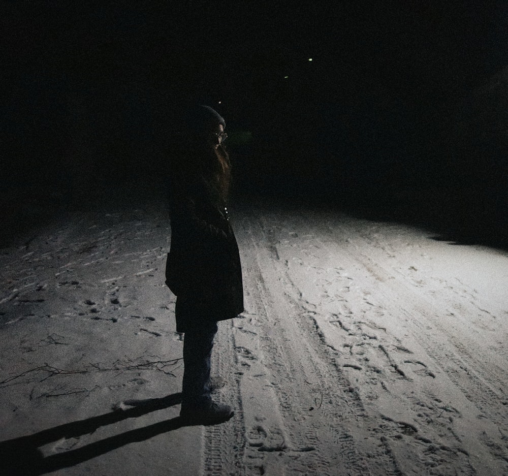 a person standing in the snow at night