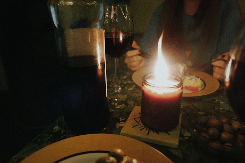 Une personne attablée à la bougie, un verre de vin devant elle