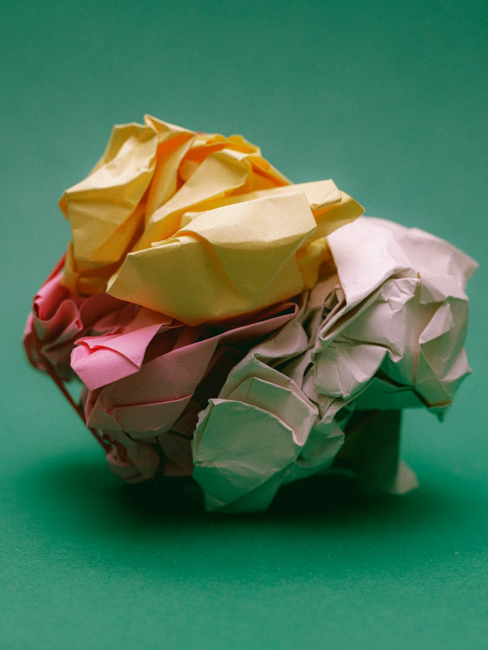 a pile of folded up paper sitting on top of a green surface