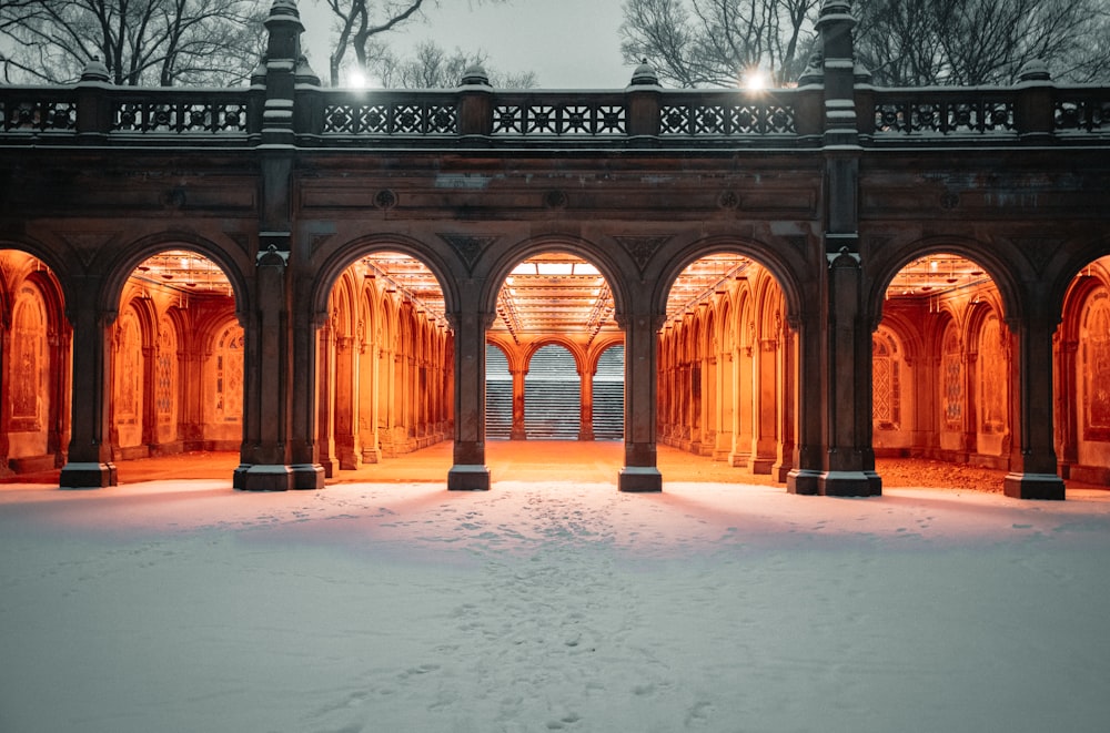 a snow covered walkway with arches and lights