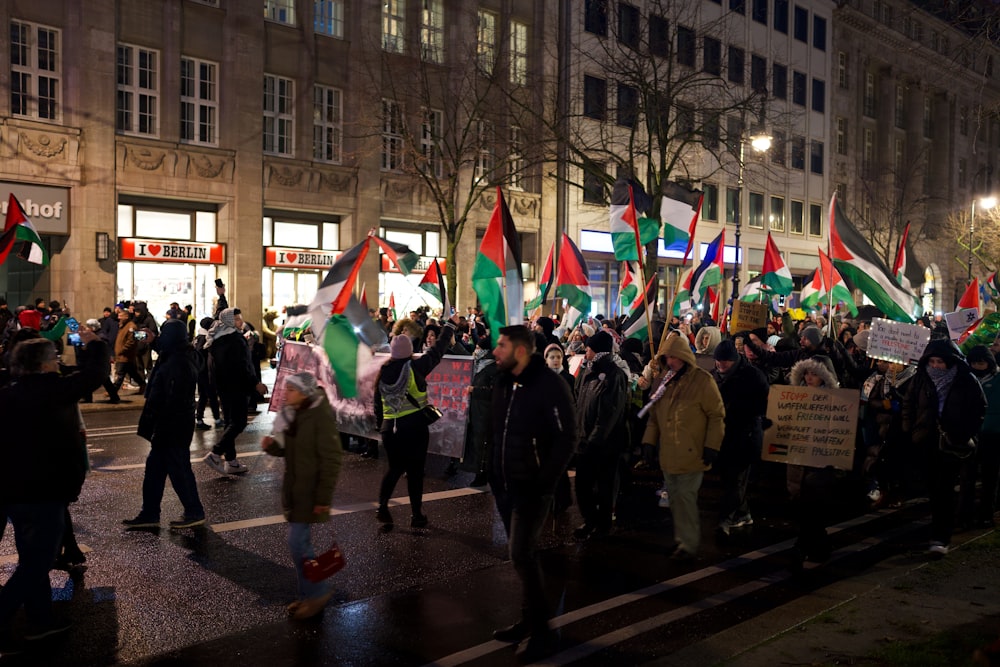 a group of people walking down a street holding flags