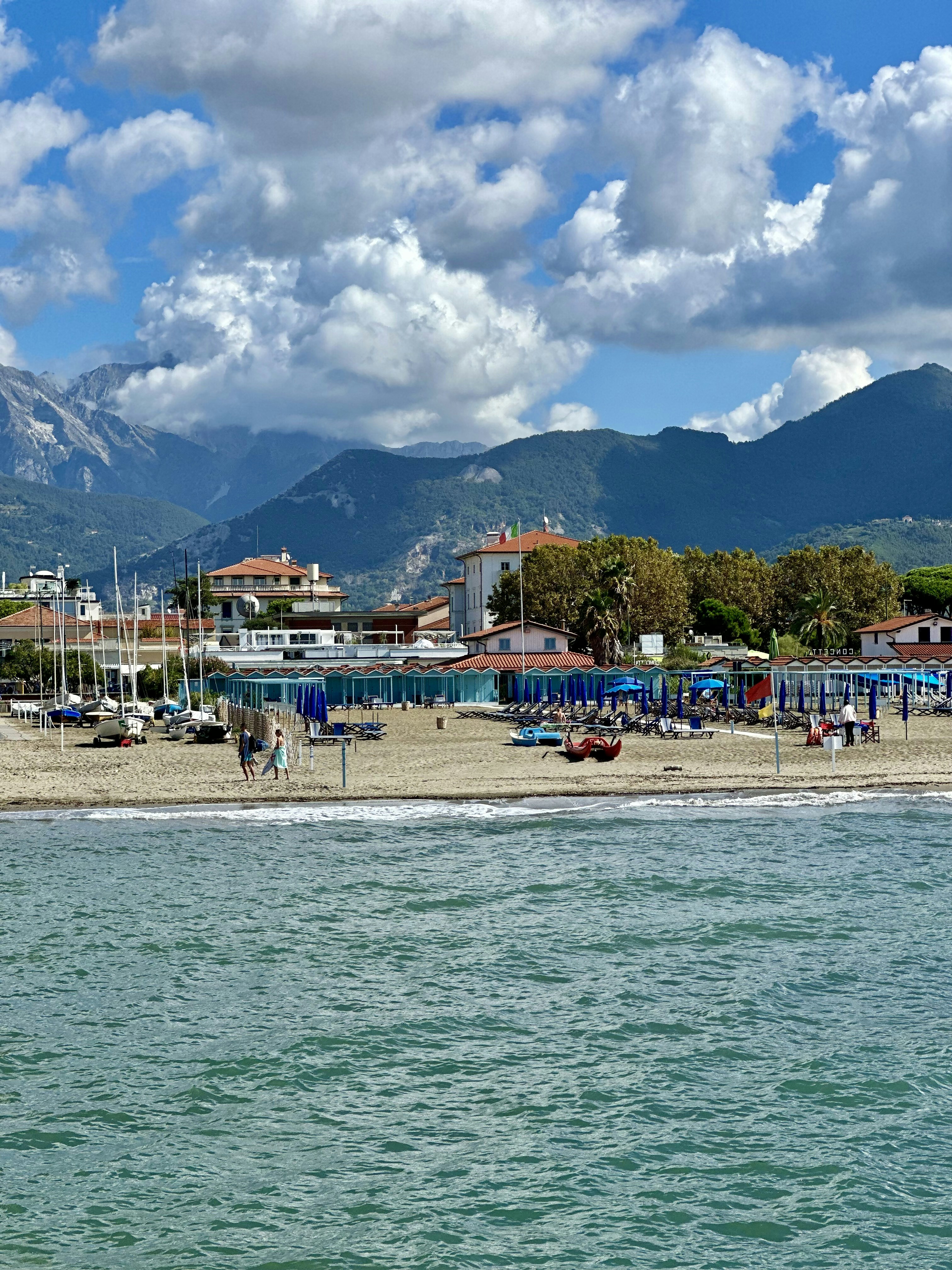 Una spiaggia con barche e montagne sullo sfondo