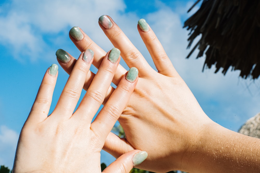 a woman's hands with green nail polish