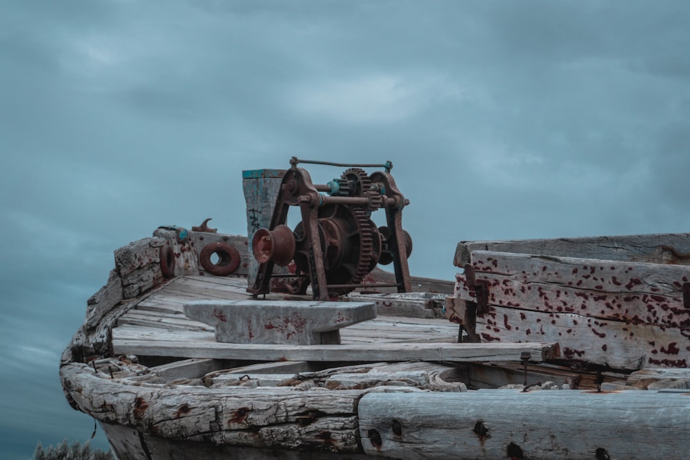 an old rusty machine sitting on top of a piece of wood