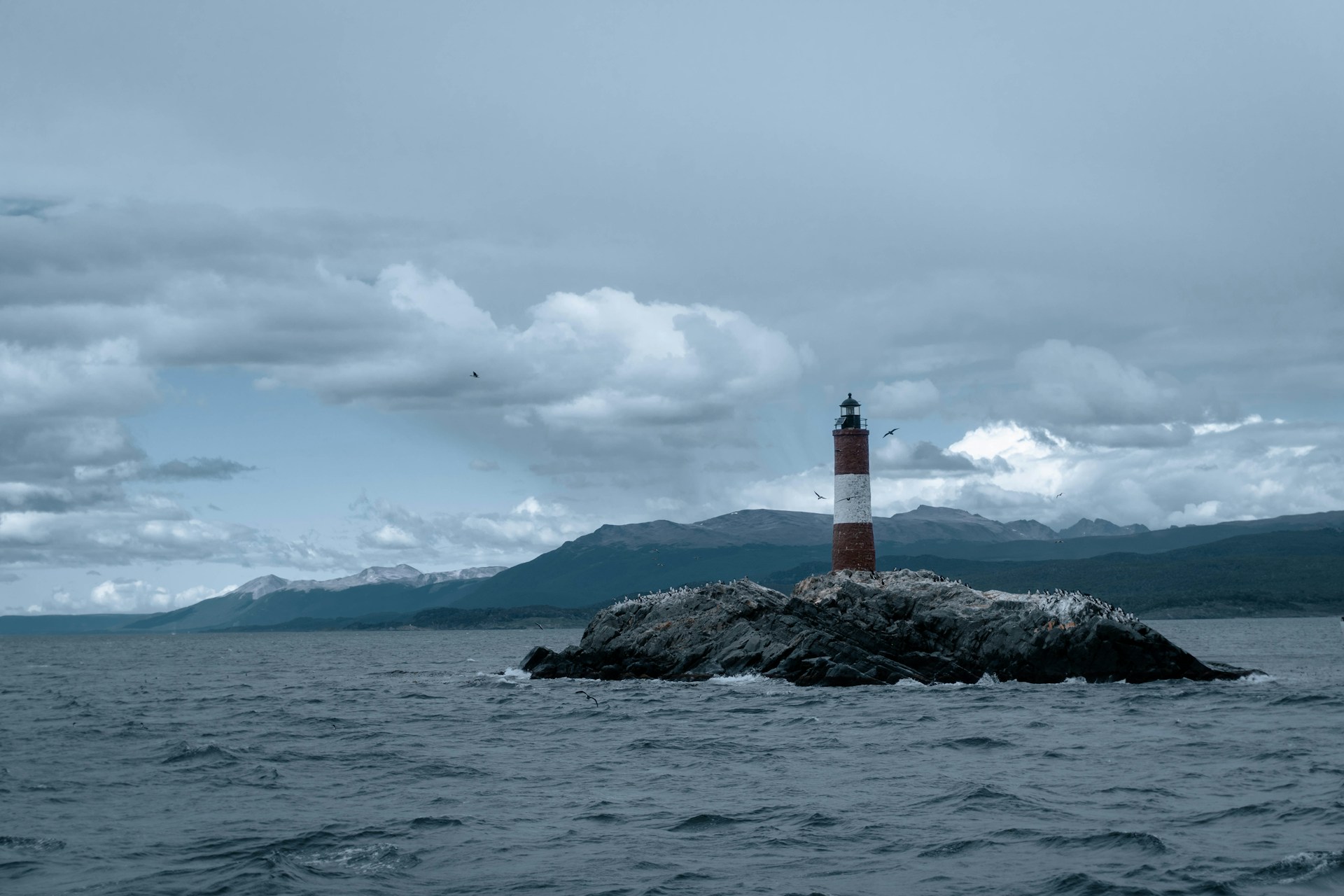 a light house sitting on top of a rock in the middle of the ocean