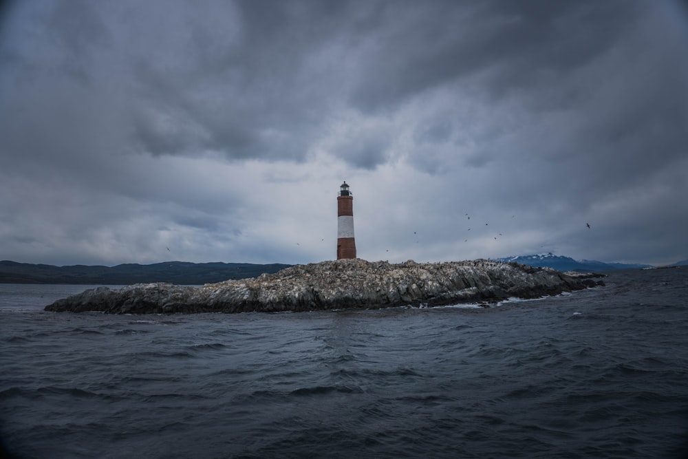 a light house sitting on top of a rock in the middle of the ocean