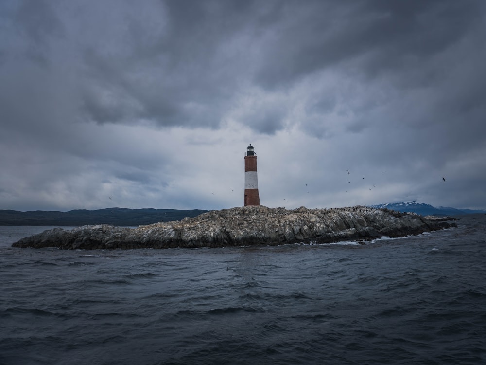 a lighthouse on a small island in the middle of the ocean