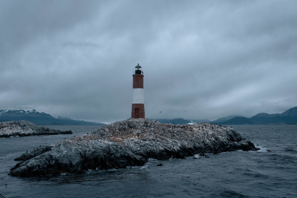 a light house on a small island in the middle of the ocean