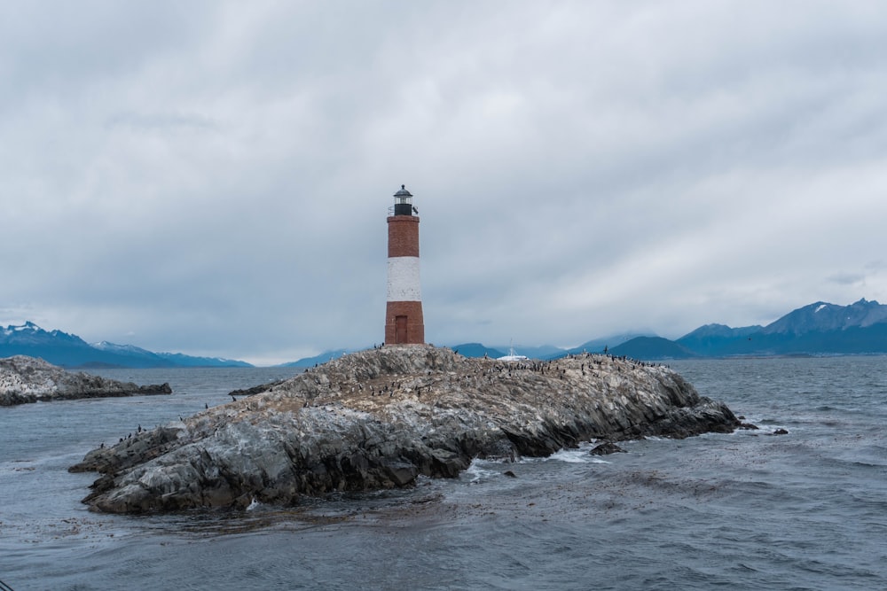 a light house sitting on top of a rock in the middle of the ocean