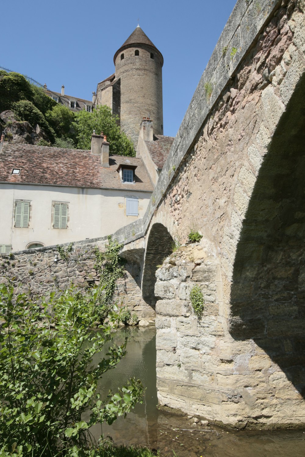 a stone bridge over a river with a castle in the background