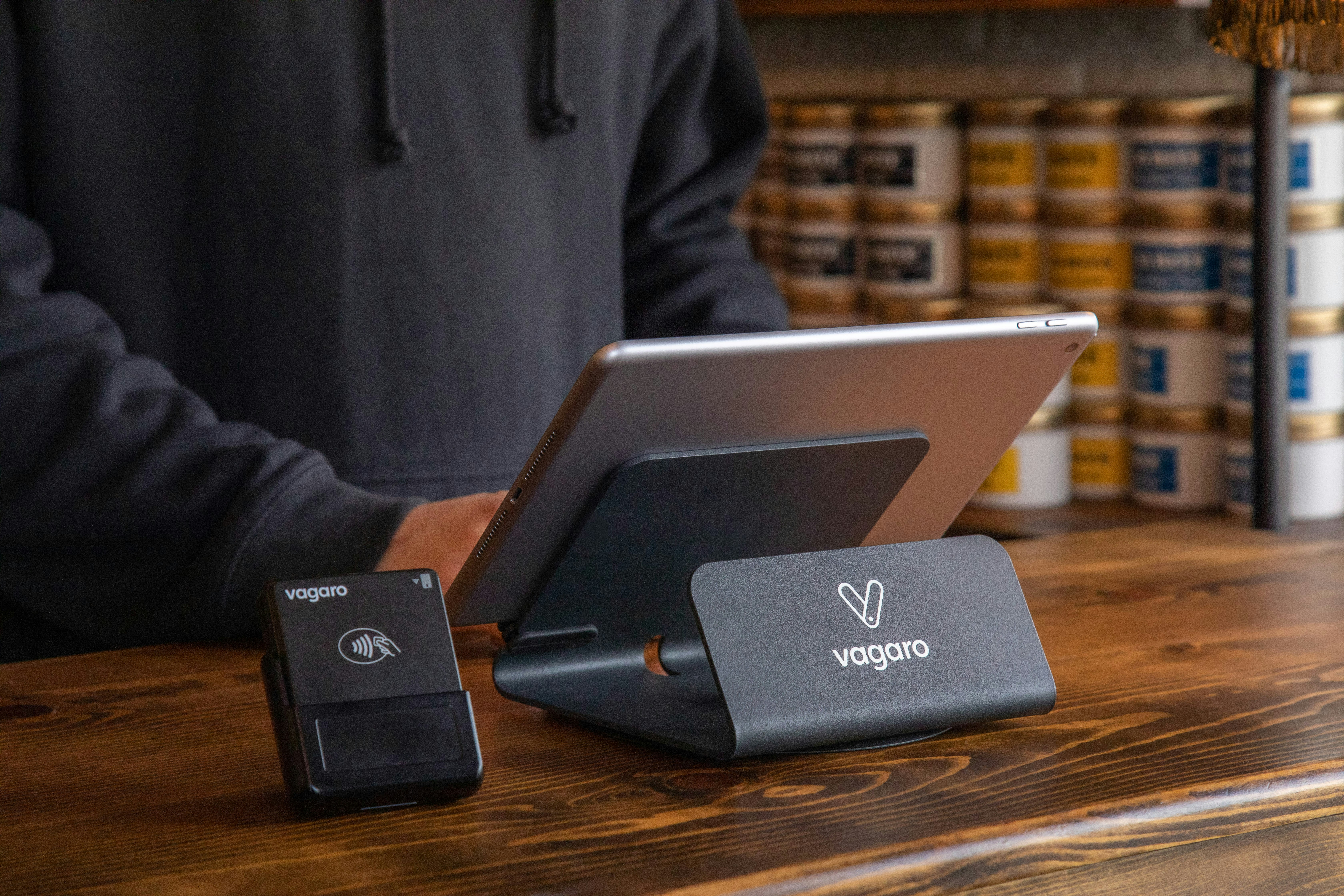 a person standing at a table with a laptop and a charger