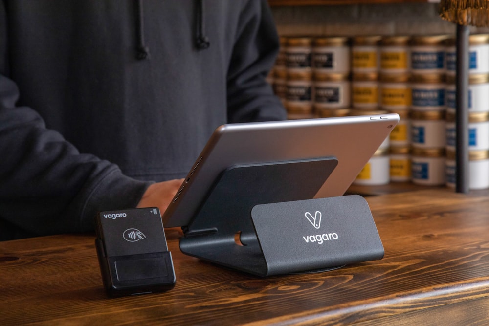 a person standing at a table with a laptop and a charger