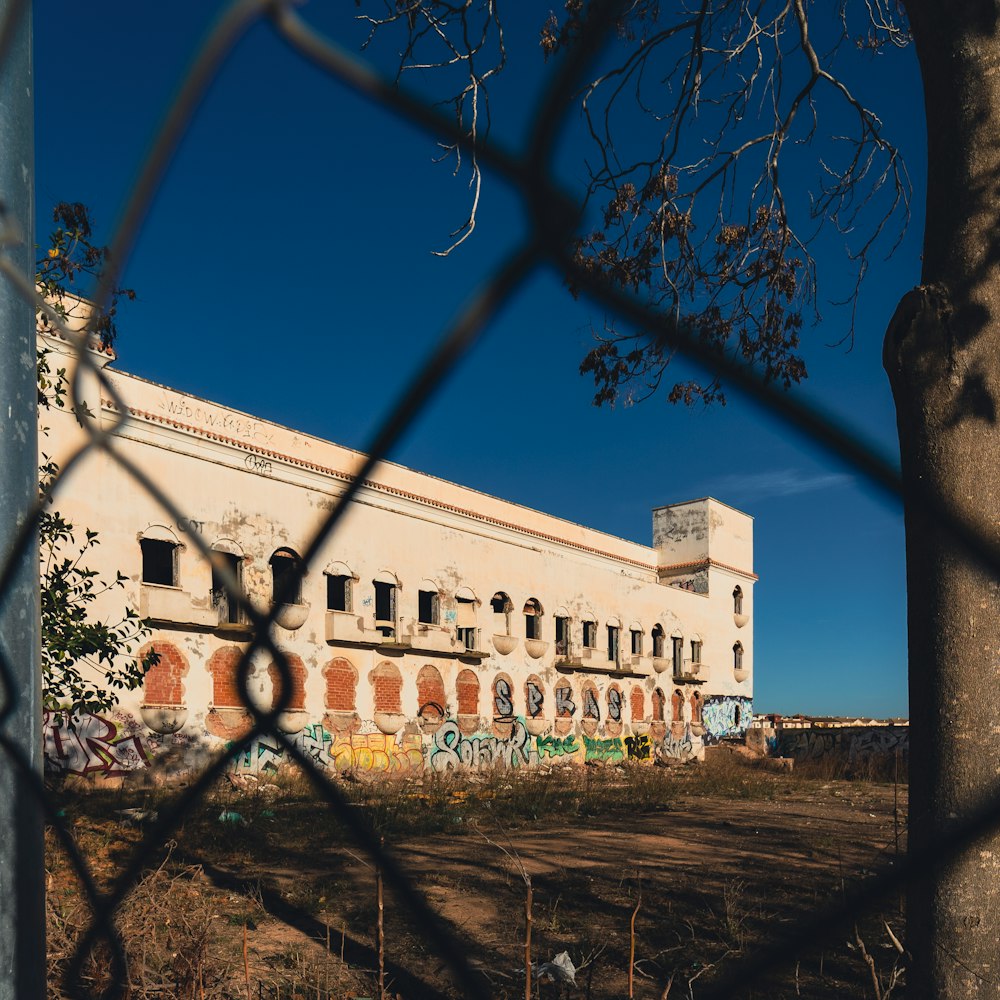 a large building behind a chain link fence