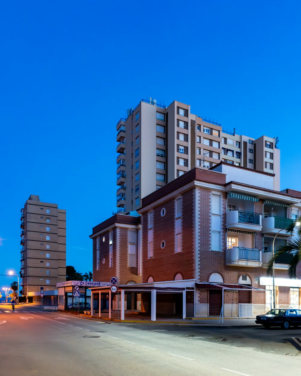 a city street at night with a large building in the background