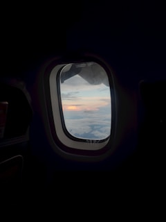 an airplane window with a view of the clouds