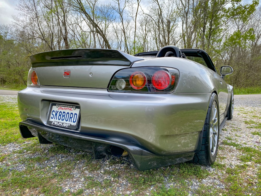 a silver sports car parked on the side of a road