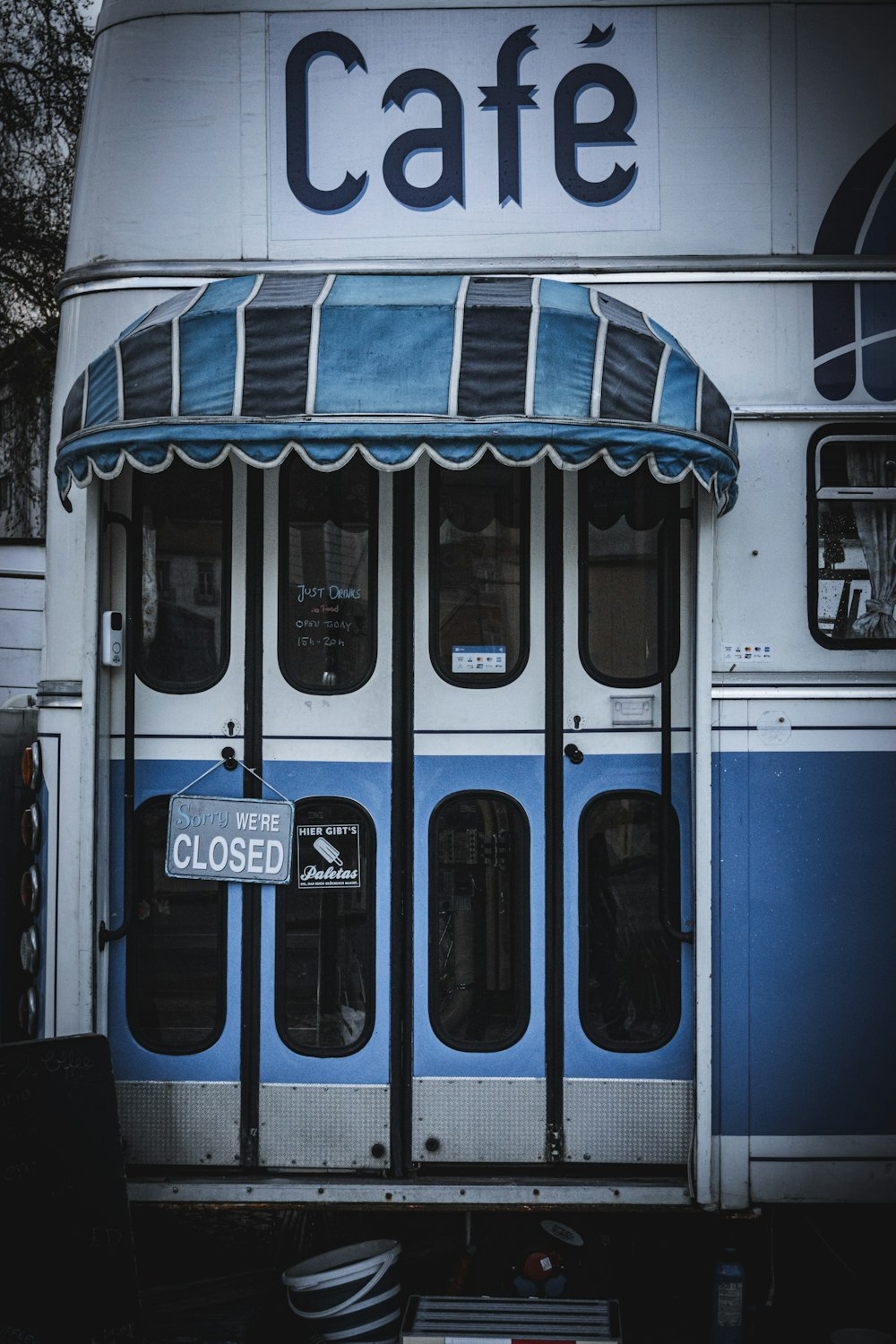 un autobus blu e bianco parcheggiato davanti a un bar