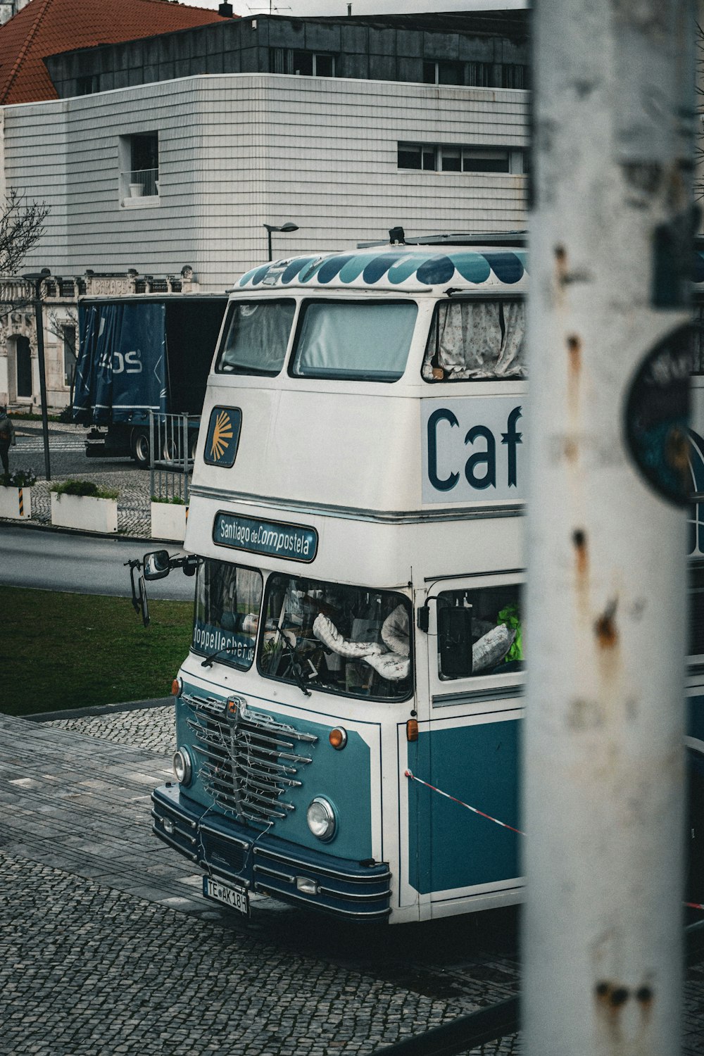 a blue and white double decker bus driving down a street