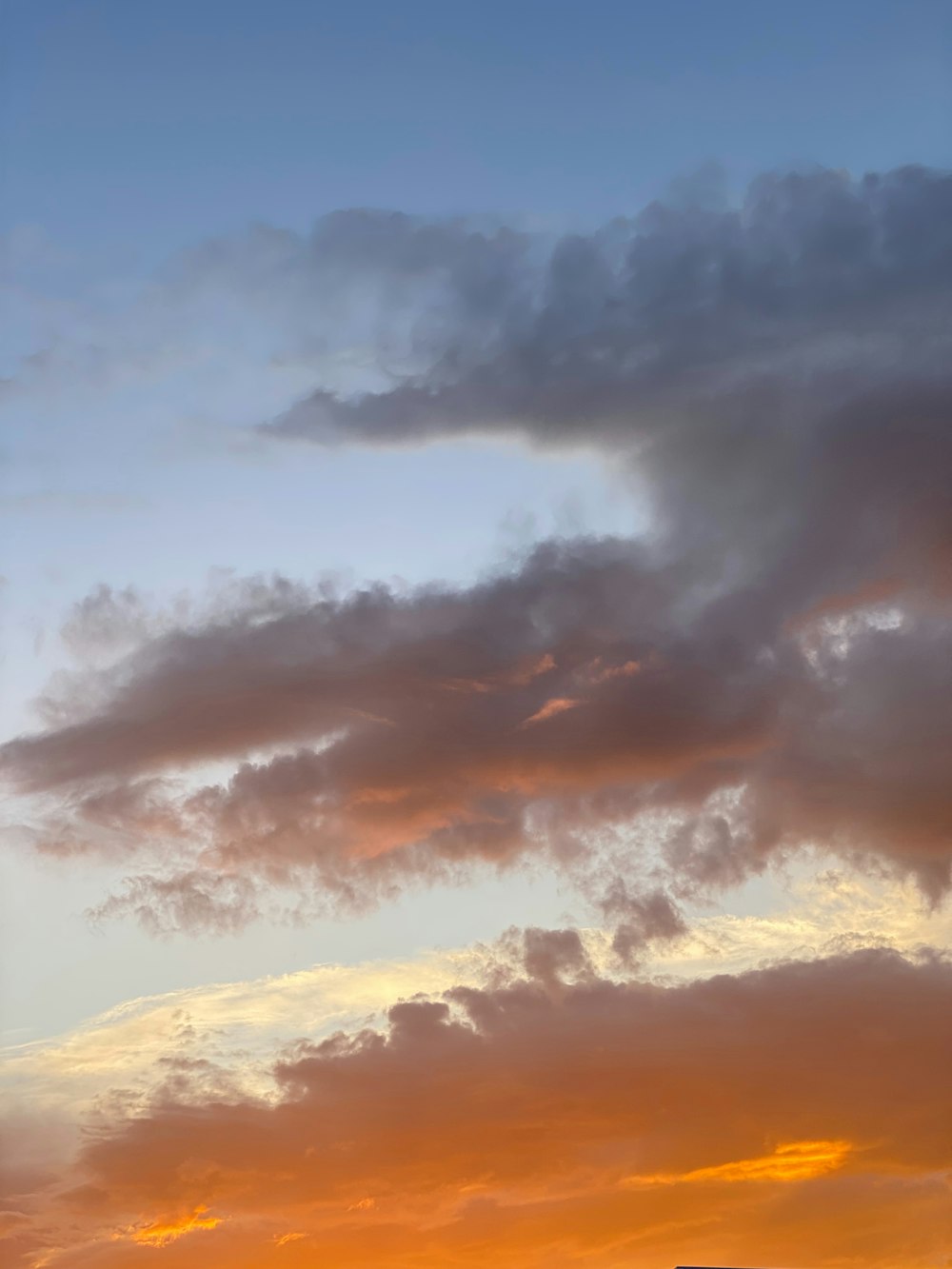 a plane flying in the sky at sunset