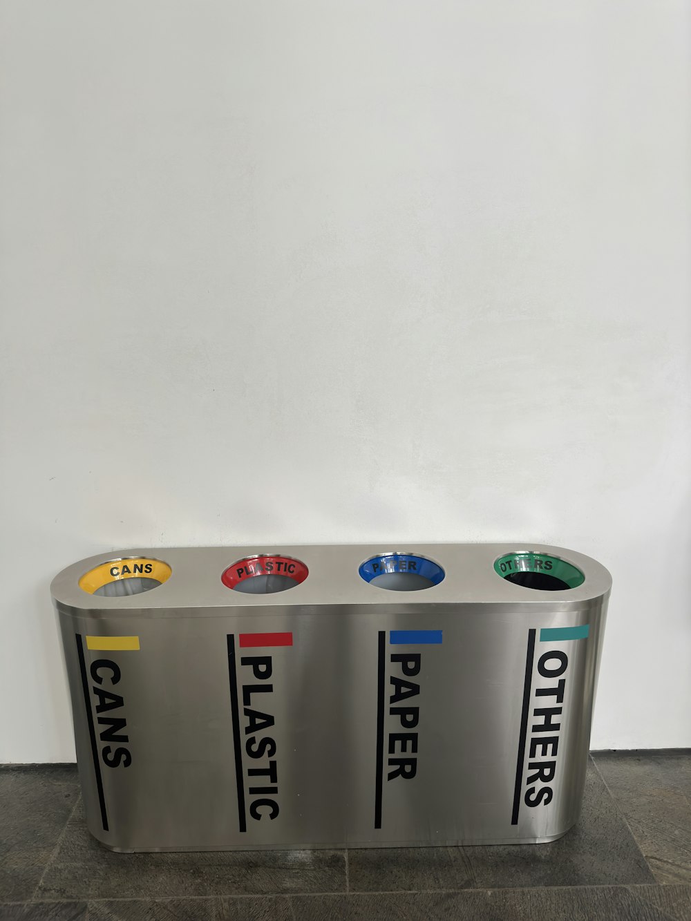 a metal trash can with three different types of trash