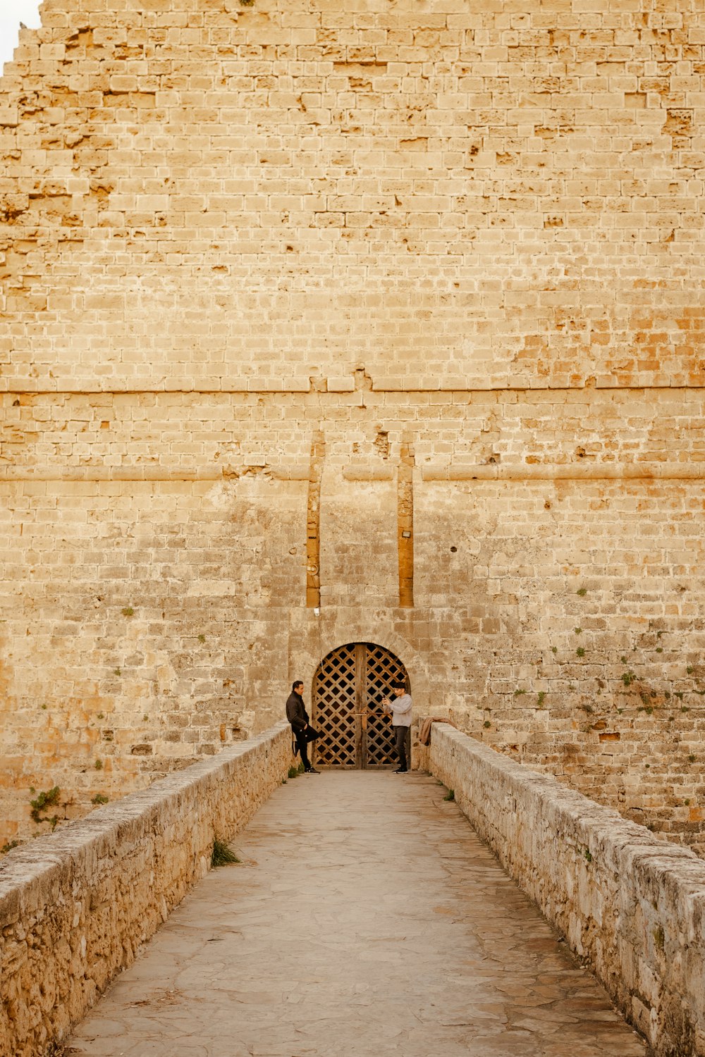 a man sitting on a stone wall next to a doorway