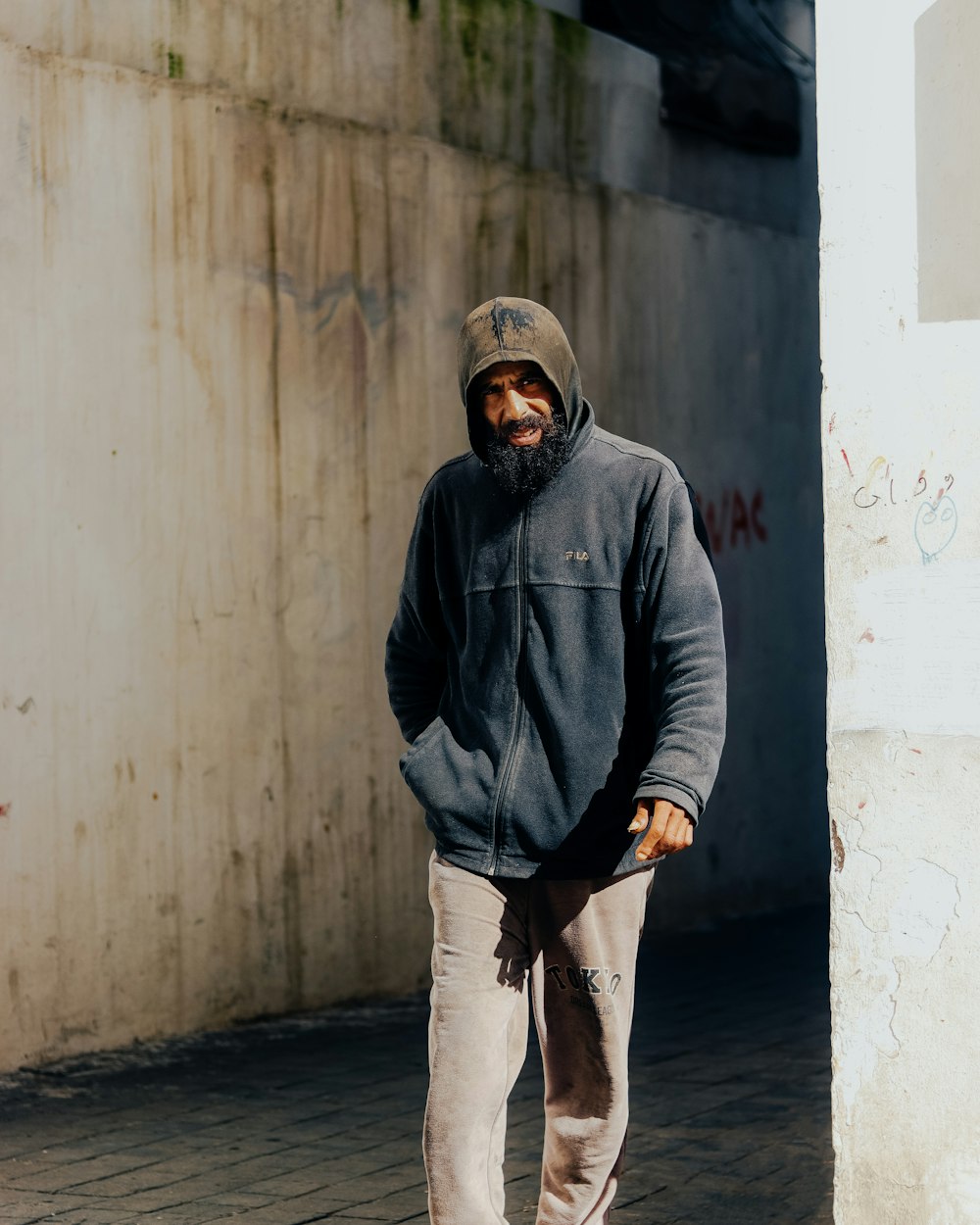 a man with a beard is walking down the street