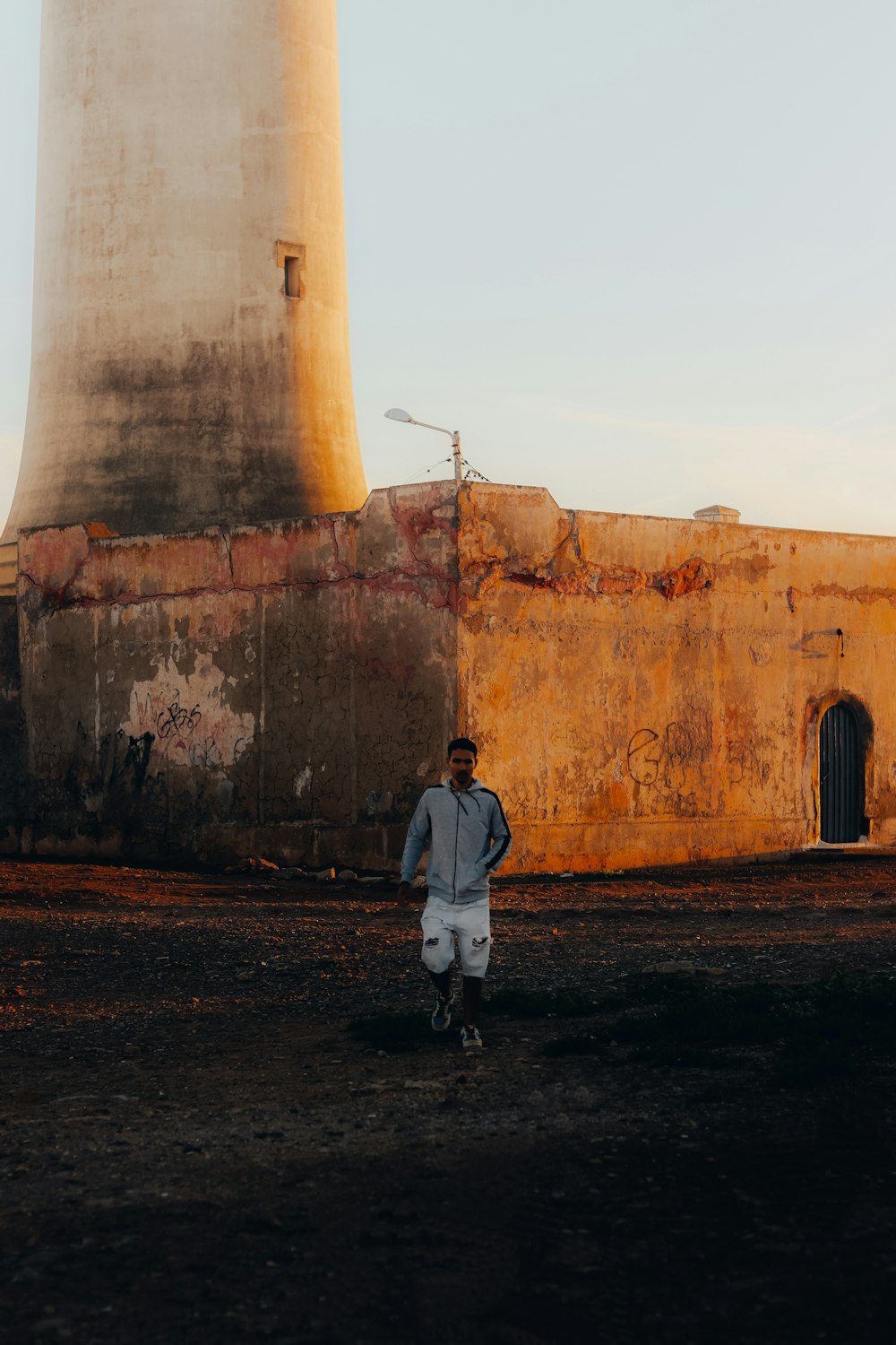 a man is standing in front of a light house