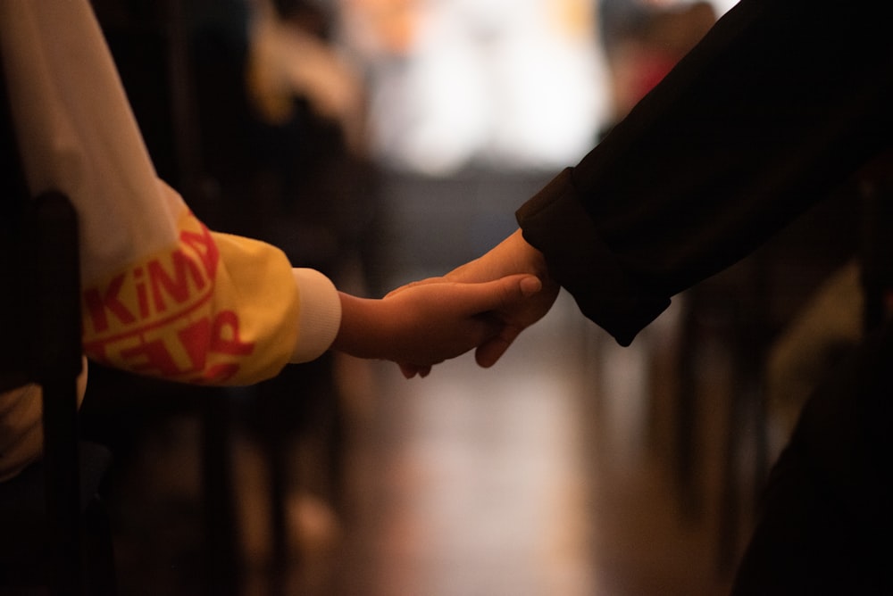 a close up of two people holding hands