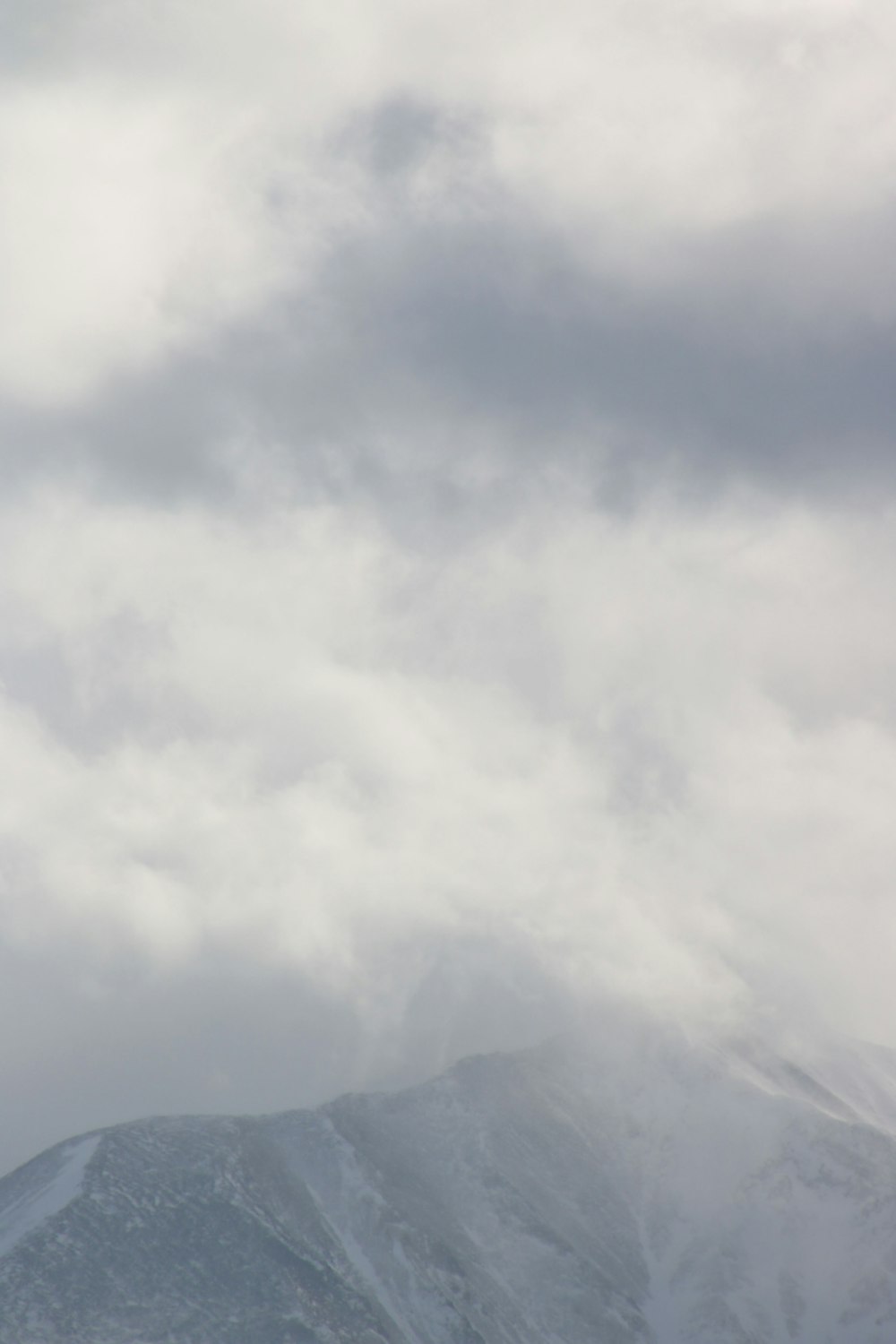 a plane flying in the sky with a mountain in the background