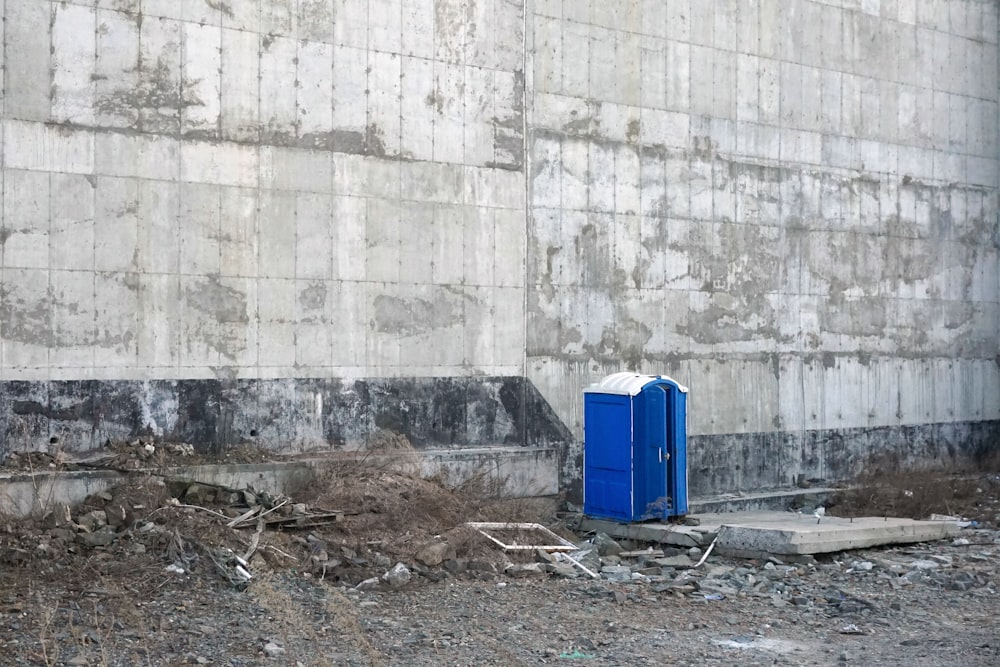 a blue box sitting in the middle of a dirt field