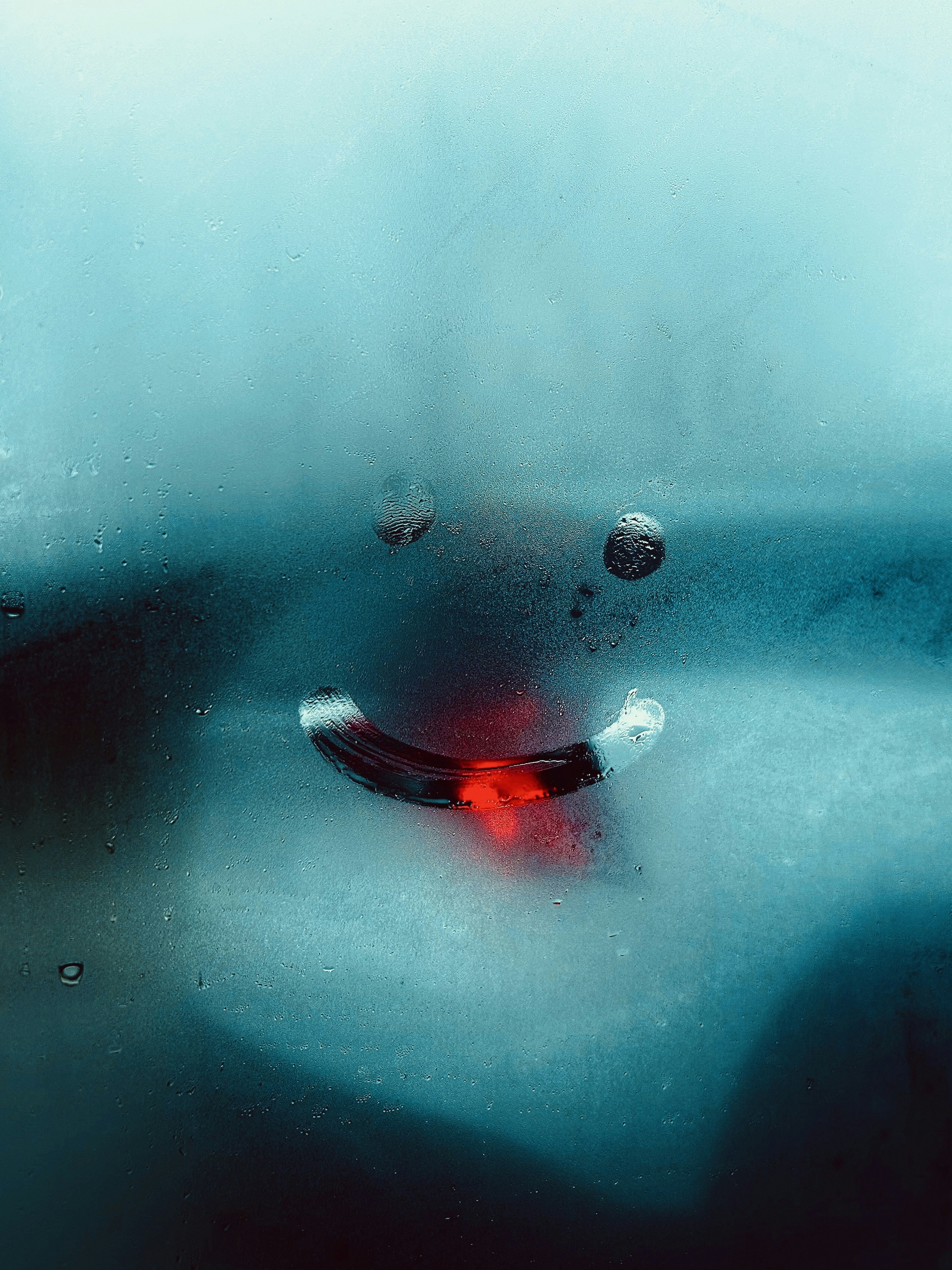 a red object sitting on top of a wet window