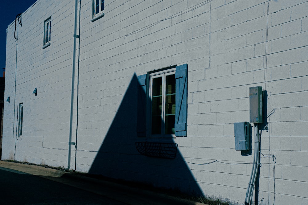 a shadow of a building on the side of a street