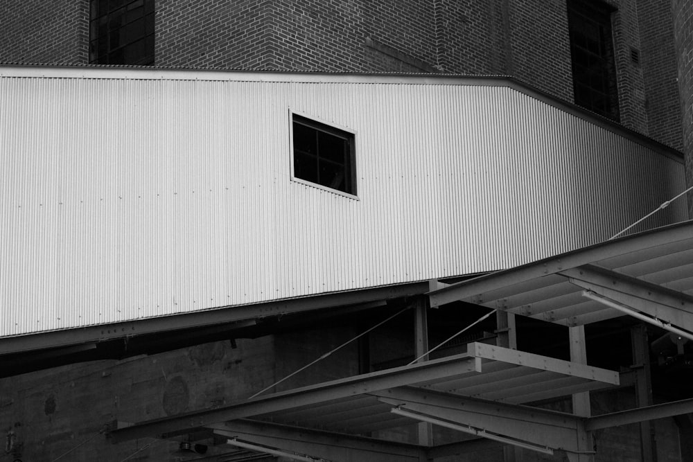 uma foto em preto e branco de um edifício com uma janela