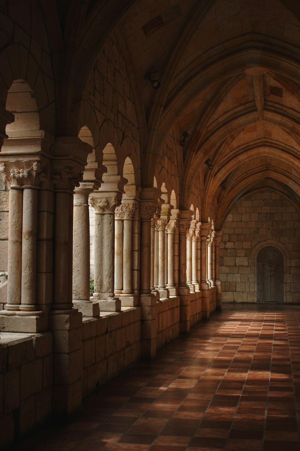 a long hallway with stone pillars and arches