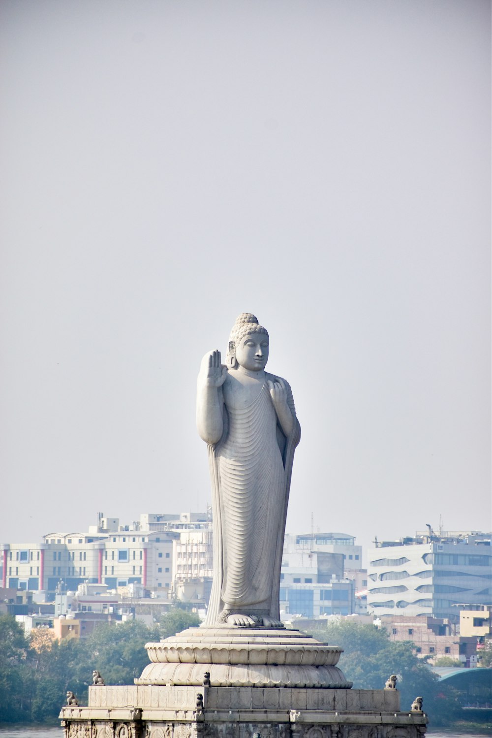 a large statue of a person standing in front of a body of water
