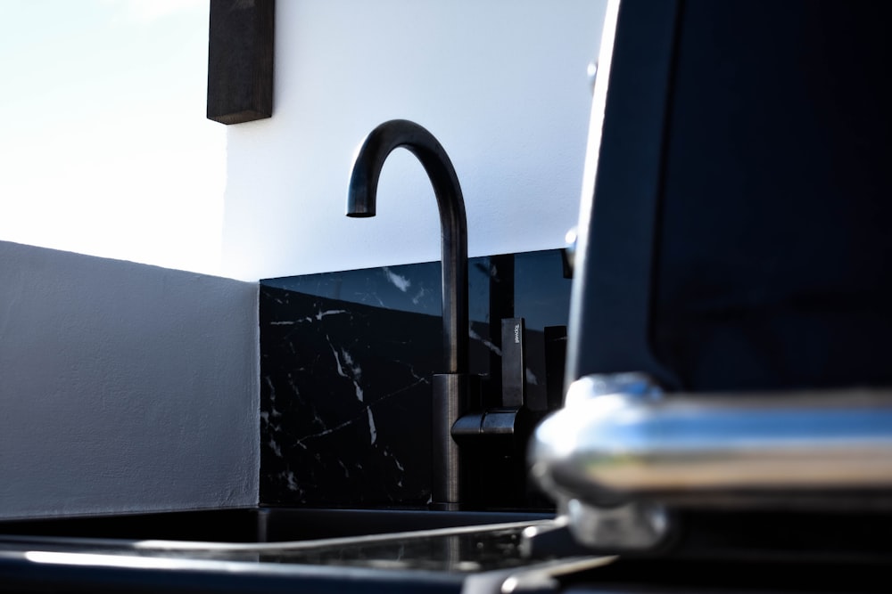 a kitchen sink with a black faucet next to it