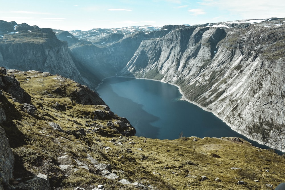 una persona de pie en un acantilado con vistas a un lago