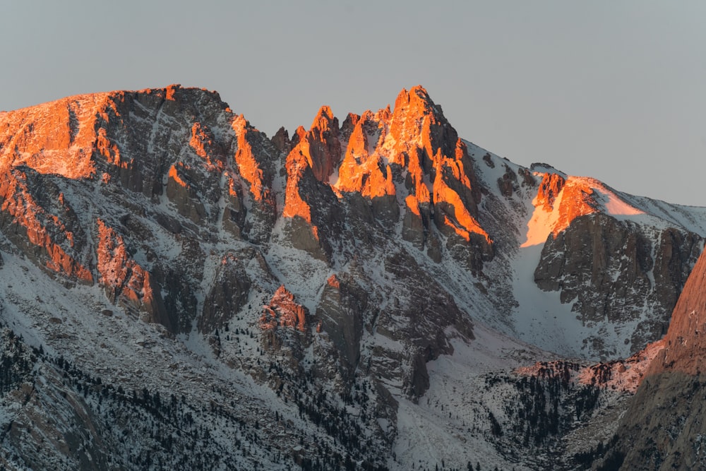 a snow covered mountain with the sun shining on it