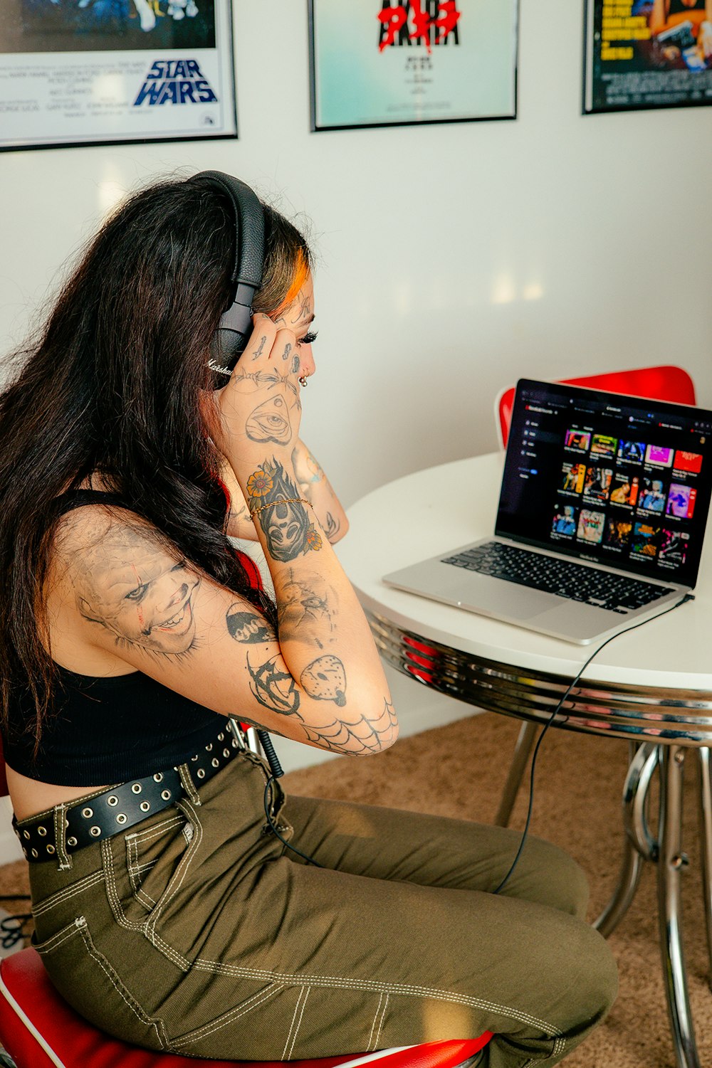 a woman sitting on the floor with a laptop and headphones