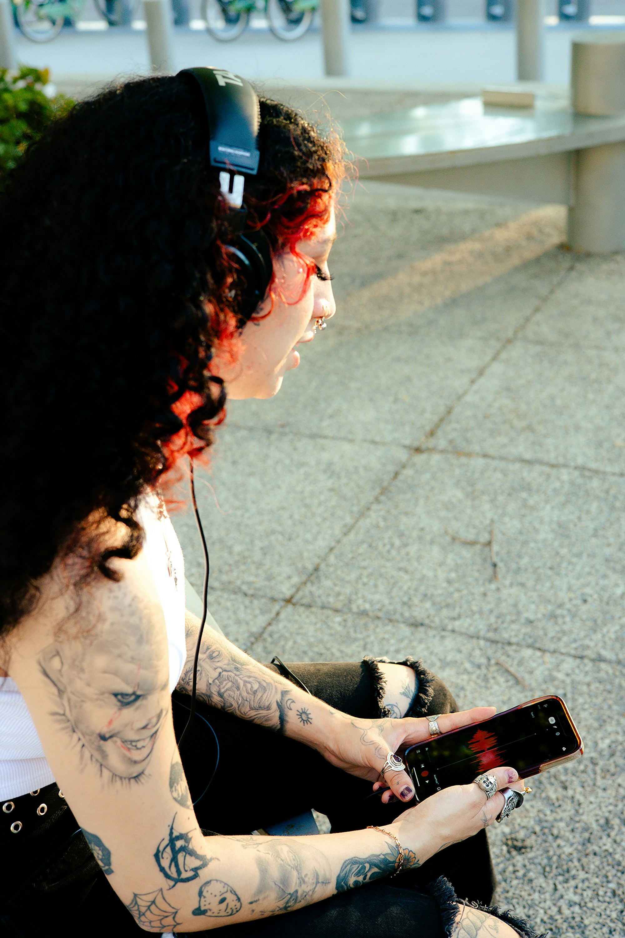 a woman sitting on the ground with headphones on