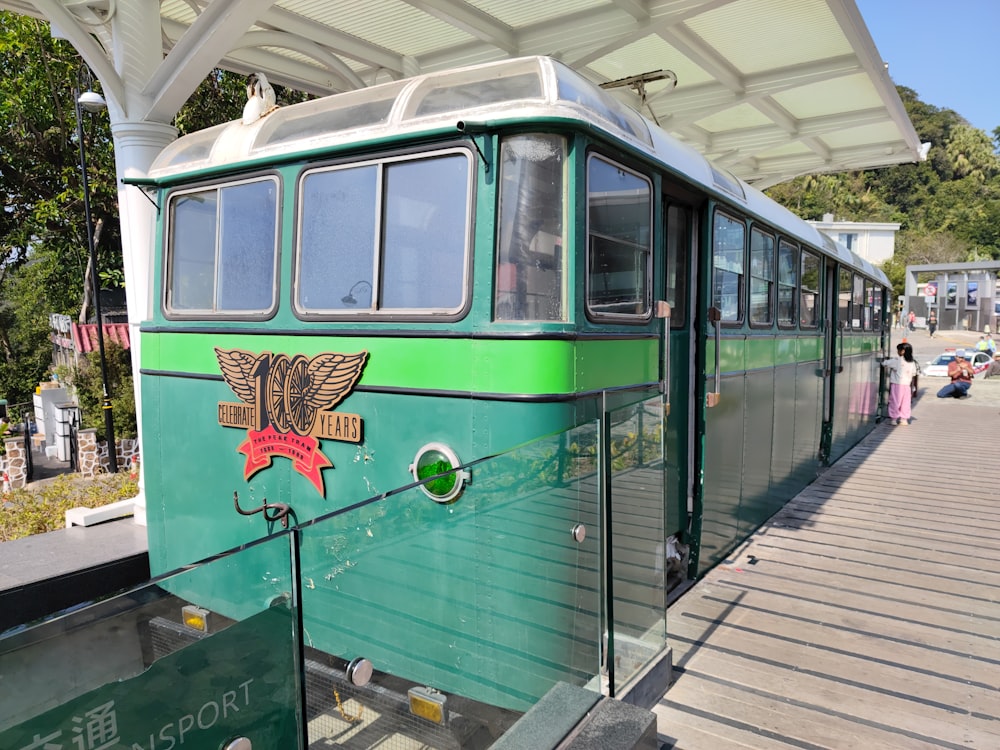 a green bus is parked on the side of the road