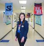 a woman standing in a hallway with banners on the wall