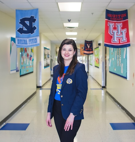 a woman standing in a hallway with banners on the wall