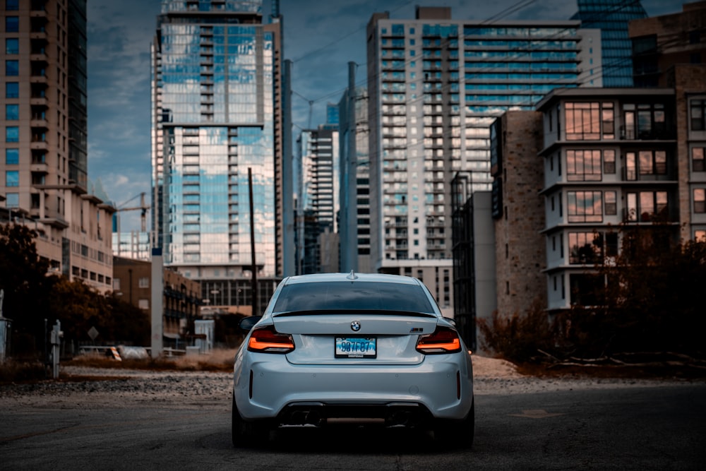 a car parked in a parking lot in front of tall buildings