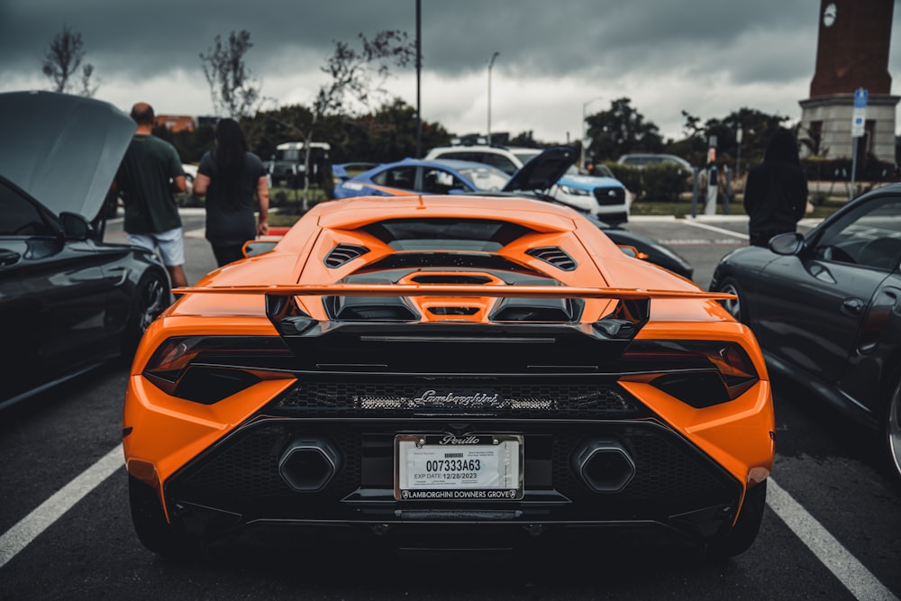 an orange sports car parked in a parking lot