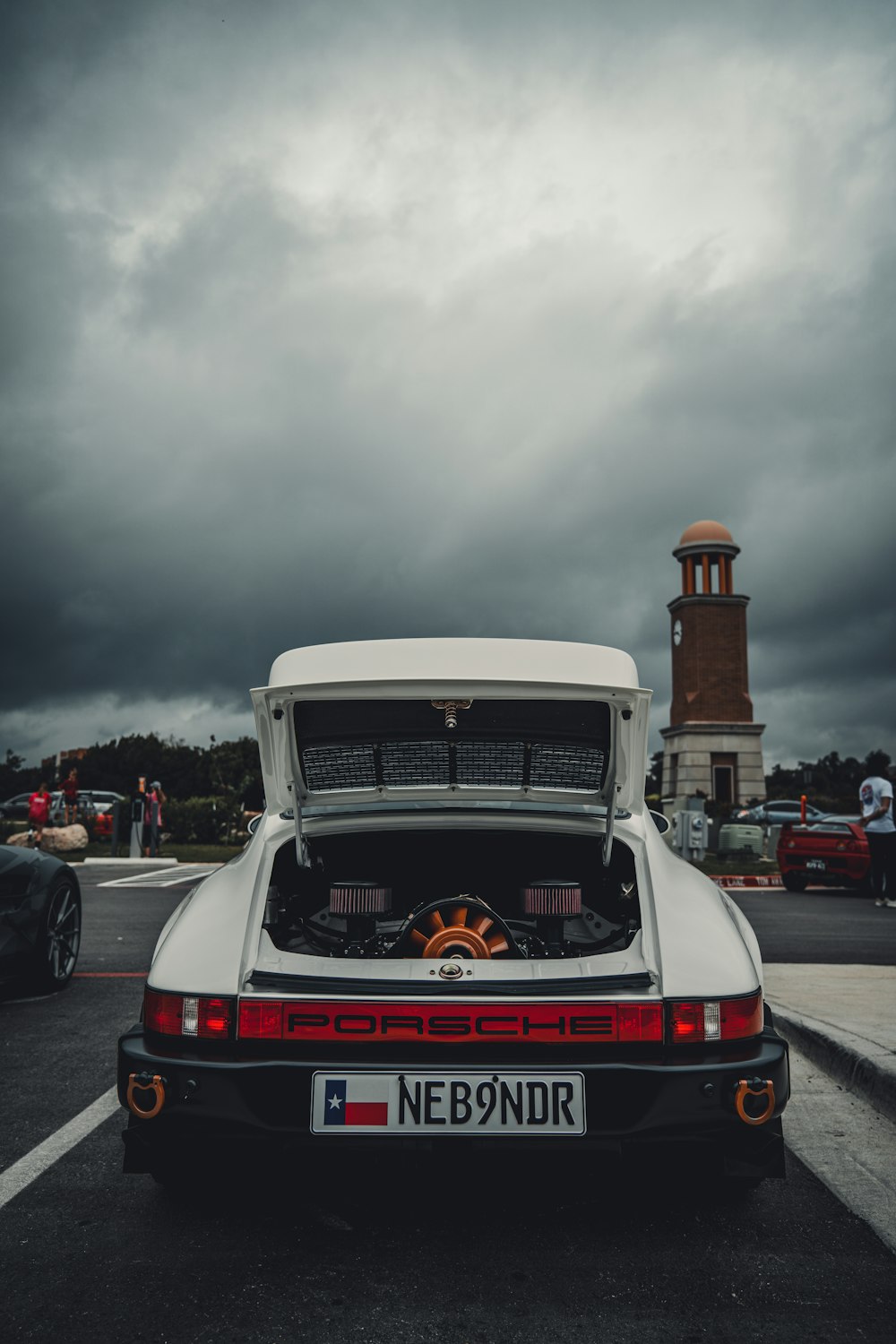 a white car parked in a parking lot under a cloudy sky