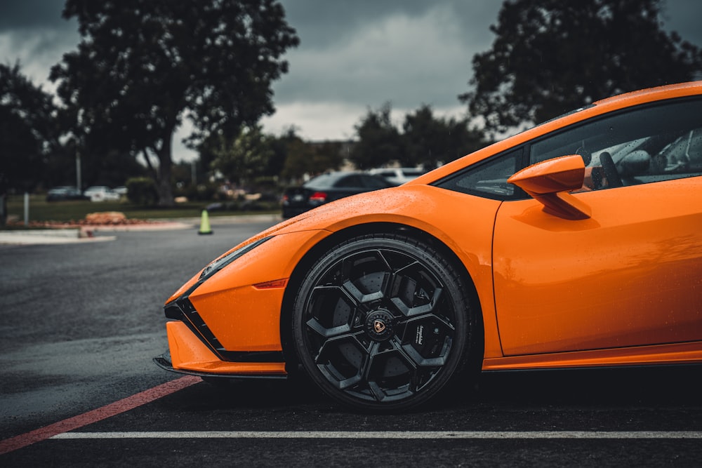an orange sports car parked in a parking lot